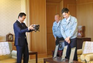 金属加工技術を活かした試作品を眺める村岡知事の写真
