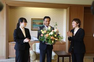 バラを使ったフラワーアレンジメントを受け取る村岡知事の写真