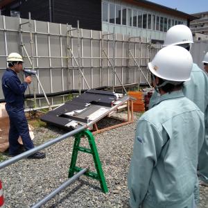 湯田温泉パーク新築工事現場において屋根の模型を見学する柳井商工高校の生徒