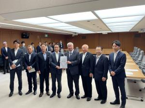 要望書を中谷防衛大臣に渡し、記念撮影に納まる村岡知事の写真