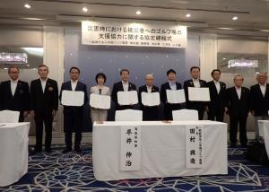 協定書への署名後、写真撮影する締結式参加者